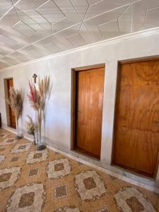 a room with two wooden doors and a tile floor at Casa en la montaña con gran vista al valle y lago in El Mollar