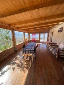 Großes Zimmer mit einem Tisch und einem Sofa in der Unterkunft Casa en la montaña con gran vista al valle y lago in El Mollar