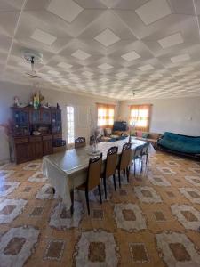 ein großes Wohnzimmer mit einem Tisch und Stühlen in der Unterkunft Casa en la montaña con gran vista al valle y lago in El Mollar