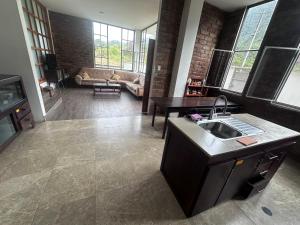 a kitchen with a sink and a living room at Baños de agua Santa in Baños