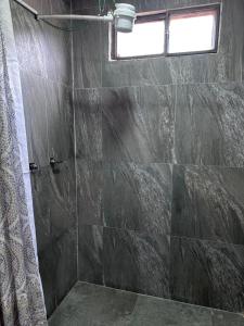 a bathroom with a shower with a stone wall at Baños de agua Santa in Baños