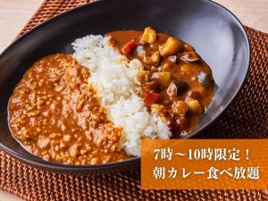 a plate of food with rice and curry at Anshin Oyado Tokyo Shinbashi Ekimaeten-Male Only in Tokyo