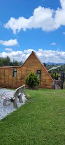 a bench sitting in front of a wooden building at Cabaña con Jacuzzi/Zona BBQ y Malla catamarán en Guarne in San Vicente
