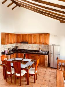 eine Küche mit einem Tisch und Stühlen sowie einem Kühlschrank in der Unterkunft BALCON DE CHIE in Villa de Leyva