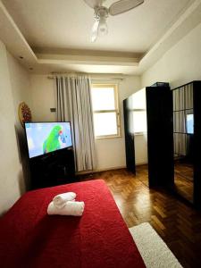 sala de estar con cama roja y TV en Apartamento Copa Surf HIR 8, en Río de Janeiro