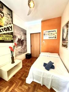 1 dormitorio con cama blanca y pared de color naranja en Apartamento Copa Surf HIR 8, en Río de Janeiro