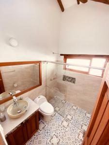 a bathroom with a toilet and a sink and a mirror at BALCON DE CHIE in Villa de Leyva