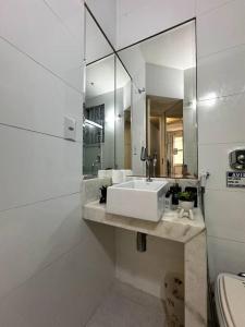 Baño blanco con lavabo y espejo en Apartamento Copa Surf HIR 8, en Río de Janeiro