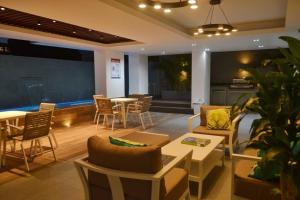 een woonkamer met een bank en tafels en stoelen bij Comfy Business Apartment in Piantini *LuxuryStay* in Santo Domingo