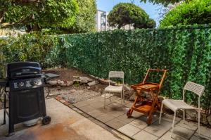 un patio trasero con una parrilla, sillas y una valla en Spacious 1 Bed + Studio // Free Parking // Zen Patio, en Seattle