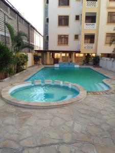 a large swimming pool in front of a building at Serena Beach View Apartment in Mombasa