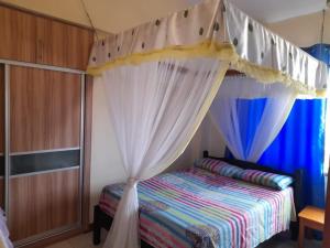 a bedroom with a bed with a canopy at Serena Beach View Apartment in Mombasa