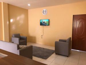 a waiting room with chairs and a clock on the wall at 1 Bedroom Apartment in Curepe