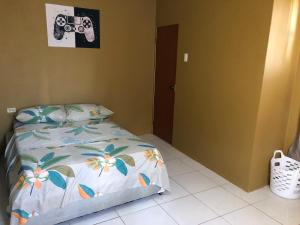 1 dormitorio con 1 cama con una cámara en la pared en 1 Bedroom Apartment, en Curepe