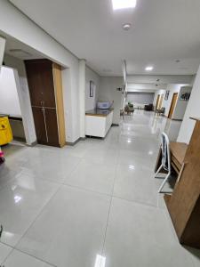 an empty room with a large white tile floor at Hotel Avelar in Ribeirão das Neves