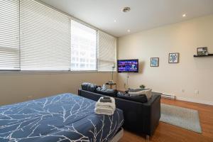 1 dormitorio con cama, sofá y TV de pantalla plana en Sunny Downtown Loft #2, en Halifax