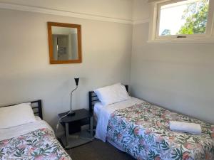 a bedroom with two beds and a mirror at Blackheath Holiday Cabins in Blackheath