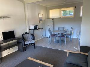 sala de estar con cocina, mesa y sillas en Blackheath Holiday Cabins, en Blackheath