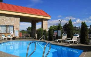 een zwembad in een resort met stoelen en een gebouw bij La Quinta Inn by Wyndham Everett in Everett