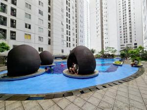 une piscine avec trois grandes balles dans une ville dans l'établissement Apt Bassura Studio Tower F w/ Pool, Wi-Fi & Netflx, à Jakarta