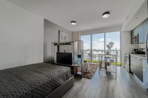 een slaapkamer met een bed en een keuken met een balkon bij TR Miami 2 Bedroom Condo and Studio with Balcony in Miami
