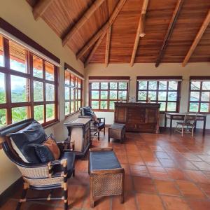 Casa Bamboo في Escobal: غرفة معيشة كبيرة مع كراسي وبيانو