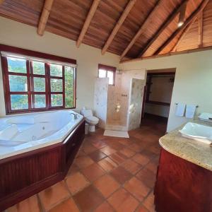 Casa Bamboo في Escobal: حمام كبير مع حوض استحمام ومرحاض