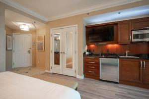 a room with a kitchen with a bed and a tv at No Resort Fee Strip View Suite + Free Valet + Pool in Las Vegas