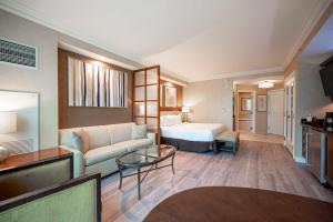 a hotel room with a couch and a bed at No Resort Fee Strip View Suite + Free Valet + Pool in Las Vegas