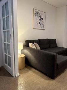 salon z czarną kanapą w pokoju w obiekcie A city oasis - cozy 1 bed apartment w mieście Perth