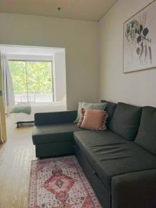 salon z zieloną kanapą i oknem w obiekcie A city oasis - cozy 1 bed apartment w mieście Perth