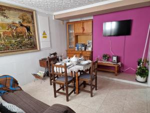 una sala da pranzo con tavolo e parete viola di Casa Rural La Replaceta a Chulilla