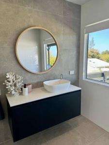 un baño con lavabo y espejo en The Old Artist Residence, Boreen Point Boutique Accomodation, en Cootharaba