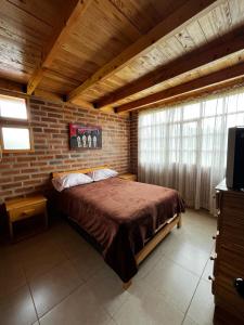 a bedroom with a large bed in a brick wall at Cabañas Tecla María in Otavalo