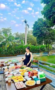a woman standing in front of a table of food at NUhome in Hòa Bình