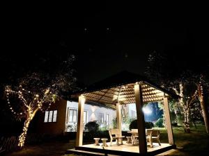 a gazebo with chairs and a table with lights at NUhome in Hòa Bình