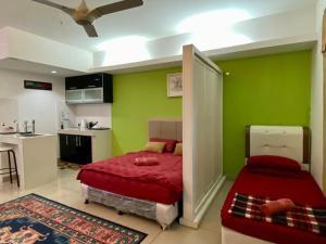 a bedroom with green walls and a bed and a kitchen at Private Studio Viana Court Service Apartment 3 with private parking in Kota Bharu