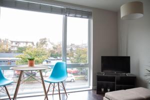 a living room with a table and chairs and a large window at Capitol Hill Modern Studio with Free Parking! in Seattle