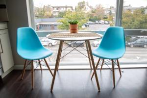 two blue chairs and a table in front of a window at Capitol Hill Modern Studio with Free Parking! in Seattle