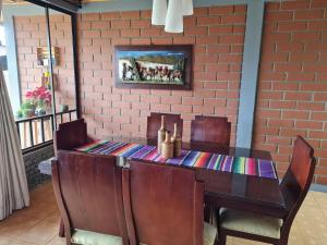 uma mesa de jantar com cadeiras e uma parede de tijolos em Casa Vélez: habitación natural em Villamaría