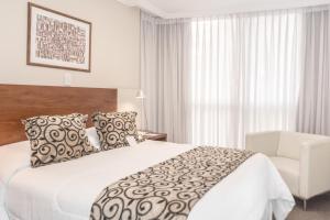 a hotel room with a bed and a chair at Palm Beach Plaza Hotel in Montevideo