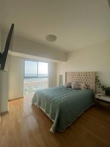 a bedroom with a large bed and a large window at Departamento con vista al mar in Lima