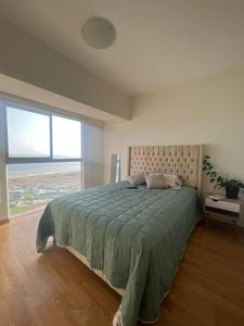 a bedroom with a bed and a large window at Departamento con vista al mar in Lima