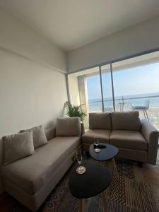 a living room with a couch and two tables at Departamento con vista al mar in Lima