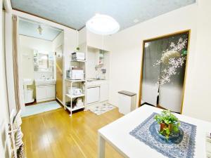 een woonkamer met een tafel en een keuken bij Petit Hotel 017 / Vacation STAY 61793 in Tokushima