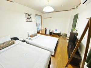 een kamer met 2 bedden en een bureau. bij Petit Hotel 017 / Vacation STAY 61793 in Tokushima