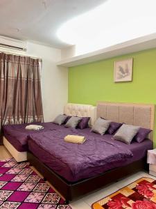 um quarto com uma cama grande e lençóis roxos em Private Studio Viana Court Service Apartment 4 with private parking em Kota Bharu
