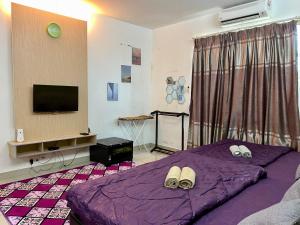 een slaapkamer met een paars bed en een flatscreen-tv bij Private Studio Viana Court Service Apartment 4 with private parking in Kota Bharu