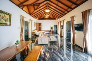 a living room with a wooden ceiling at de Bintan Villa in Tenaga