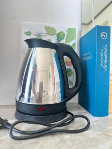 a tea kettle sitting on a counter next to a box at Ban Suweena in Uthai Thani